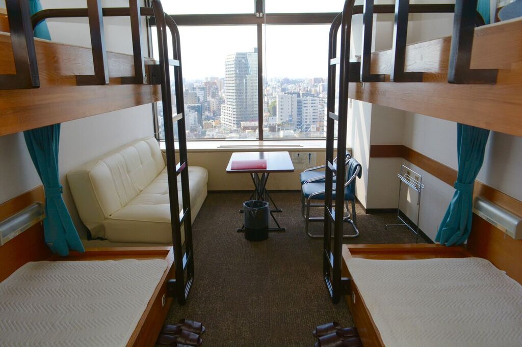 東京セントラルユースホステルの二段ベットが２つ並んだ客室とそこから見える東京を一望できる景色