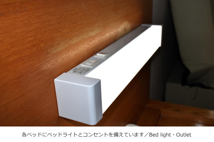 東京セントラルユースホステルの洋室のベッドライトとコンセント