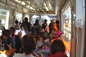 お母さんと子どもと東京セントラルユースホステルの職員が都内のバスで目的地に着くまで楽しくお話ししている様子